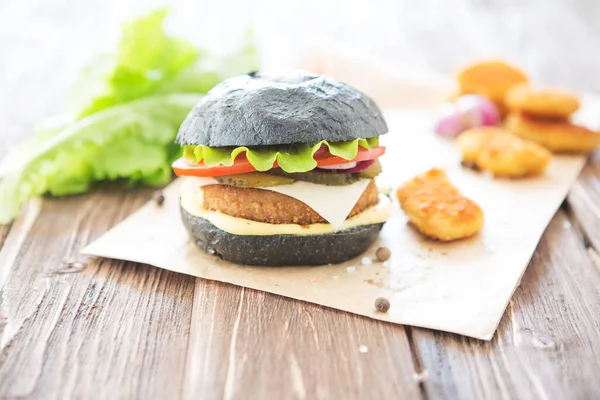 Lezzetli fast food. Siyah arka planda izole edilmiş bir siyah burger. Görünümün üstünde.