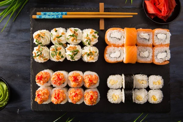 Siyah arka planda wasabi ve zencefilli suşi ruloları. Japon Doğu mutfağı.