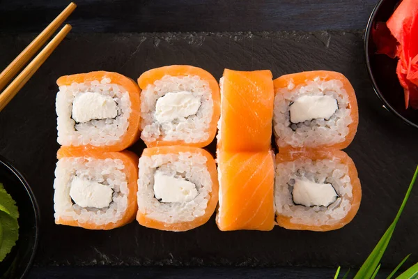 Siyah arka planda wasabi ve zencefilli suşi ruloları. Japon Doğu mutfağı.