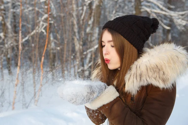 美丽的冬季姑娘在寒冷的冬季公园里吹雪 飞雪雪花 阳光灿烂的日子 快乐美丽的年轻女子在冬园玩乐 — 图库照片