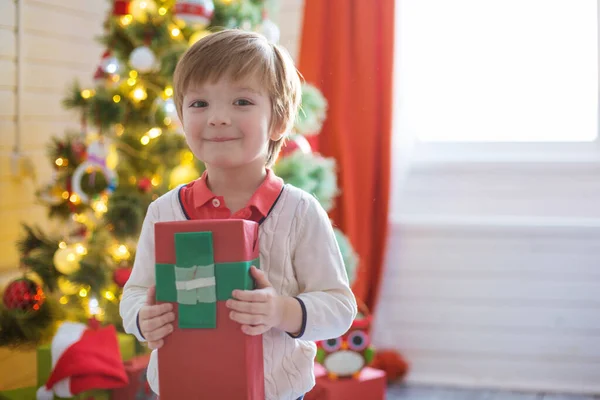 Щасливий Маленький Хлопчик Тримає Різдвяні Подарунки Біля Новорічної Ялинки — стокове фото