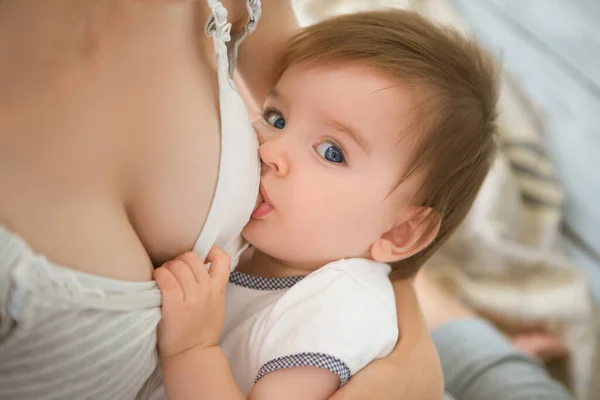 母亲在家里抱着孩子喂哺母乳 妈妈用母乳喂她的新生儿 婴儿吃母亲的奶 哺乳期婴儿的概念 — 图库照片