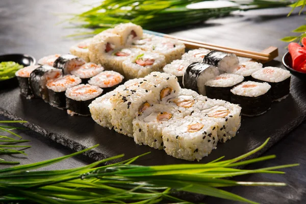 Siyah arka planda wasabi ve zencefilli suşi ruloları. Japon Doğu mutfağı.