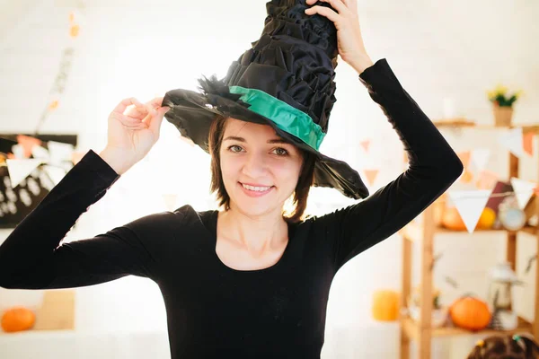 ハロウィンのお祝いのための準備ができて魔女衣装の若い美しい女性ハロウィンルーム装飾 — ストック写真