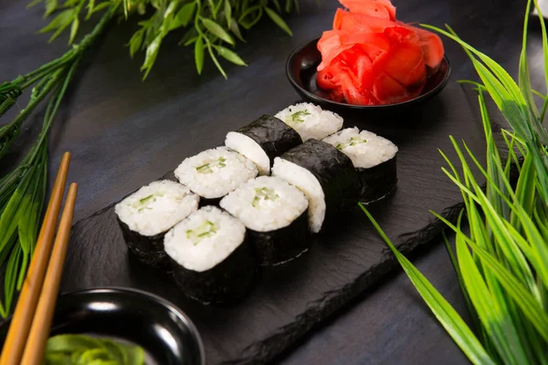 Siyah arka planda wasabi ve zencefilli suşi ruloları. Japon Doğu mutfağı.