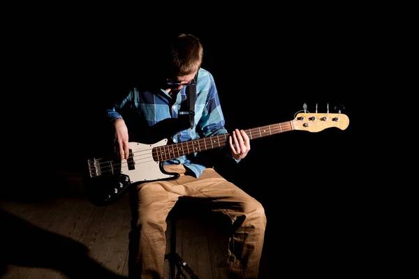 어두운 배경에서 베이스 기타를 연주하는 — 스톡 사진