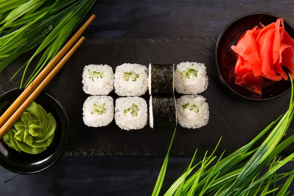 Siyah arka planda wasabi ve zencefilli suşi ruloları. Japon Doğu mutfağı.