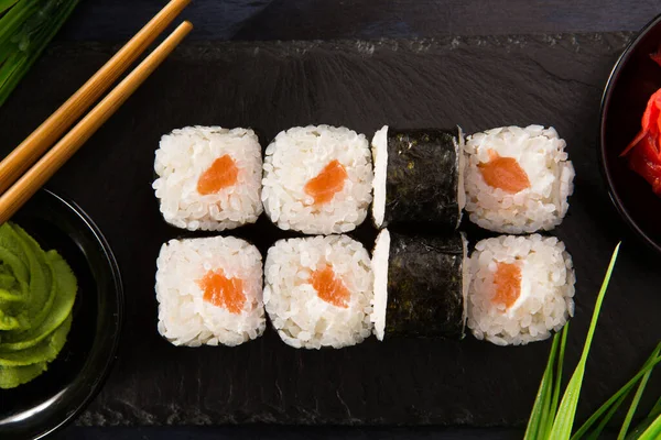 Siyah arka planda wasabi ve zencefilli suşi ruloları. Japon Doğu mutfağı.