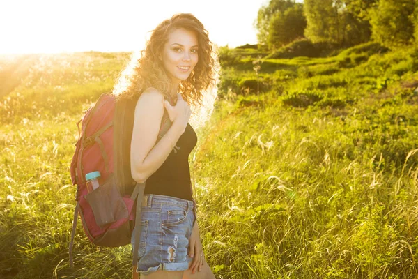 Sınırları olmayan bir dünya. Dağlardaki kızın çarpıcı yolculuğu. Sırt çantalı şık hippi kadın yazın muhteşem ormanlara ve dağlara bakıyor. Seyahat konsepti.
