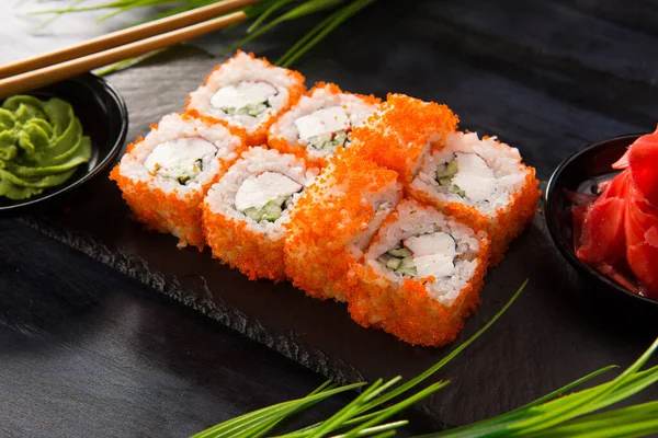 Siyah arka planda wasabi ve zencefilli suşi ruloları. Japon Doğu mutfağı.