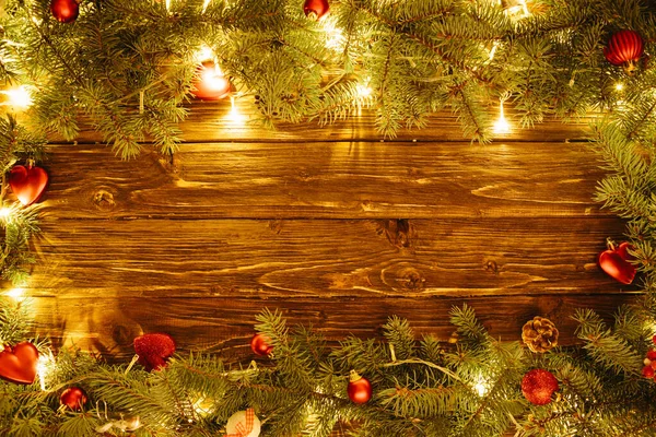 Noel ağacı, mücevher ve açık renk çelenk ile sınır çizimi Noel arkaplanı, köknar dalları, peri ışıkları ve kahverengi ahşap üzerine noel süslemeleri