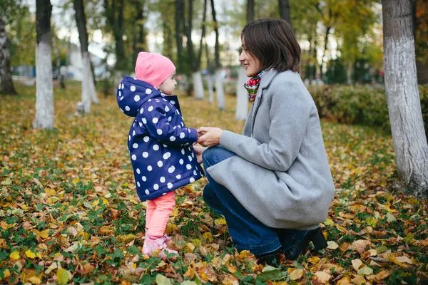 Aile bulutlu bir günde sonbahar parkında yürür..