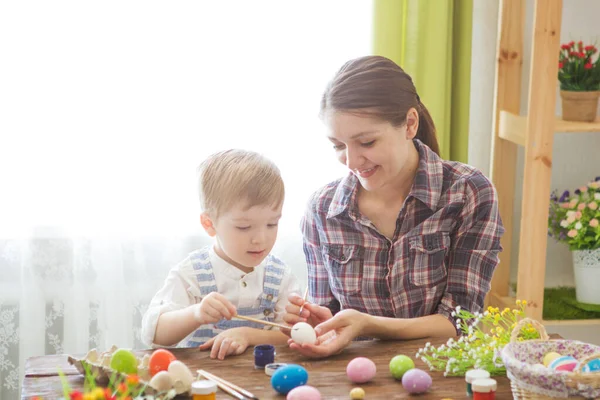 Paskalya yumurtası boyarken mutlu zamanlar. Paskalya konsepti. Mutlu anne ve tatlı çocuğu yumurtaları boyayarak Paskalya için hazırlanıyorlar..