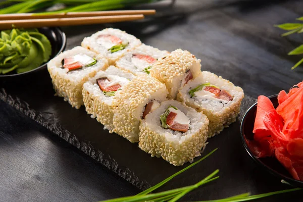Siyah arka planda wasabi ve zencefilli suşi ruloları. Japon Doğu mutfağı.