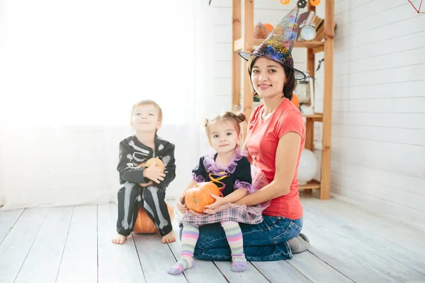 母と子供の幸せな家族は家を飾るためにハロウィーンの準備をします — ストック写真