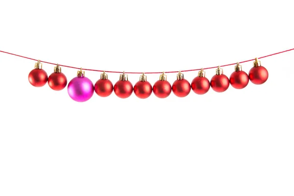 Linia Czerwonych Bożonarodzeniowych Kulek Jedna Liliowa Lub Fioletowa Kula Białym — Zdjęcie stockowe