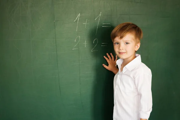 Kleiner Süßer Schulbub Steht Neben Der Schultafel Und Mathe Aufgaben Stockfoto