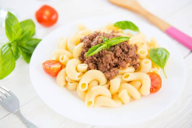 Mutfak masasında salamlı makarna ve biftek sosu..