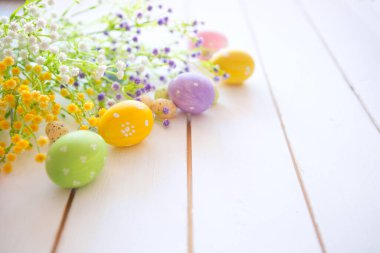 Beyaz ahşap arka planda çiçekli Paskalya yumurtaları