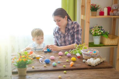 Bir anne ve oğlu Paskalya yumurtası boyuyor. Mutlu aile Paskalya için hazırlanıyor. Mutlu Paskalyalar.