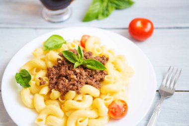 Domates soslu makarna sığır eti, ahşap bir masada domatesler..