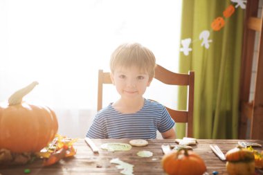 Cadılar Bayramı 'nda korsan kostümü giymiş küçük bir çocuk. Çocuklar balkabağı kabağı kabağı oyuyor. Çocuklar Cadılar Bayramı 'nı kutlar. Aile şakası mı şeker mi.