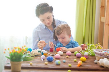 Bir anne ve oğlu Paskalya yumurtası boyuyor. Mutlu aile Paskalya için hazırlanıyor. Mutlu Paskalyalar.