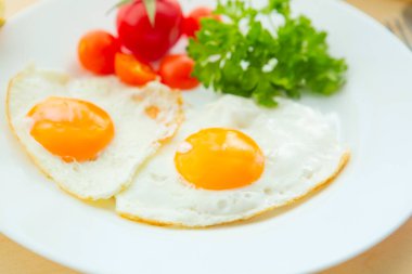 Kırsal ahşap arka planda bir tabakta kızarmış yumurta.