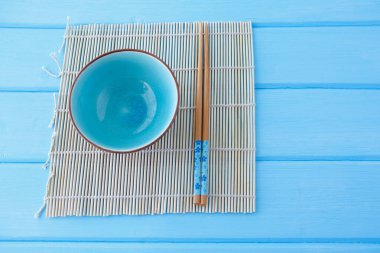 Makis 'in üzerinde suşi ve çubuk yemek için temiz mavi bir masa.