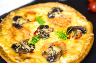 Siyah taş yüzeyde mantarlı pizza..