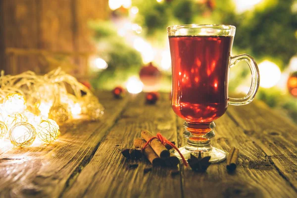 Weihnachtlicher Glühwein Auf Holztisch Über Defokussiertem Christbaumhintergrund Getöntes Bild — Stockfoto