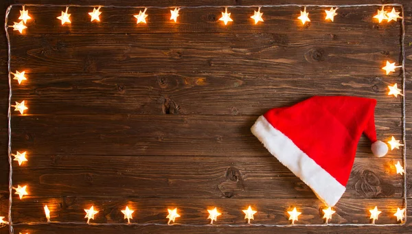 Žluté Vánoční Světlo Santa Claus Klobouk Přes Rustikální Dřevěné Pozadí — Stock fotografie