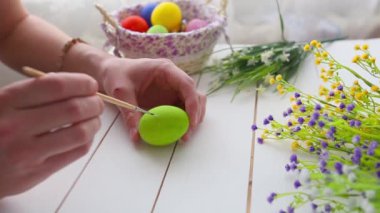 dişi eller kırsal ahşap arka planda yumurta boyuyor..