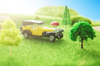 Sarı oyuncak araba çim tarlasında park halinde