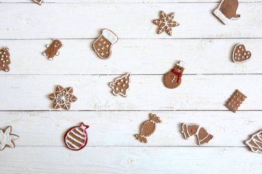 Mutlu Noeller! Kış ya da Noel arkaplanında ahşap masada kraliyet kreması ile süslenmiş zencefilli kurabiye. Güzel tebrik kartı..