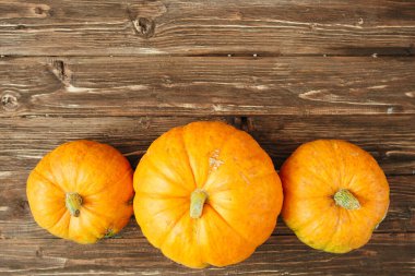 Eski ahşap arka planda sonbahar portakallı balkabakları. Fotokopi uzayı Şükran Günü ve Cadılar Bayramı konsepti. Yukarıdan bak. Üst Manzara. Metin ve tasarım için boşluk kopyala