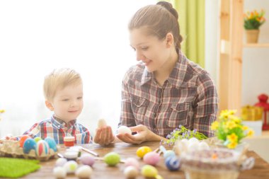 Anne ve oğlu yumurta boyuyor. Paskalya için hazırlanıyorlar..