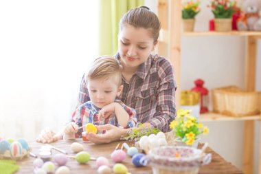 Paskalya yumurtası boyarken mutlu zamanlar. Paskalya konsepti. Mutlu anne ve tatlı çocuğu yumurtaları boyayarak Paskalya için hazırlanıyorlar..