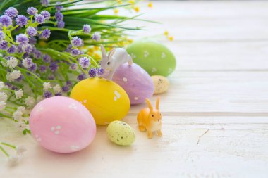 Kırsal ahşap arka planda Paskalya yumurtası ve çiçek süslemesi. Klasik tonlu bir resim. Tavşan oyuncakları.