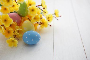 Beyaz ahşap arka planda renkli paskalya yumurtaları. Mutlu Paskalyalar.