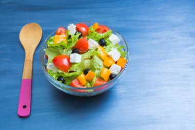 Koyu gri ahşap ya da metal masadaki cam kasede Yunan salatası