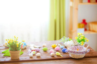 Evdeki ahşap masada renkli paskalya yumurtaları ve fırçalar..