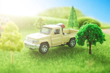 Yeşil çimlerin üzerinde beyaz kamyonet oyuncağı.