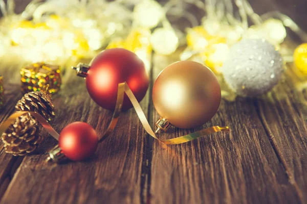 Vintage Christmas background with christmas baubles on wooden background over christmas lights.