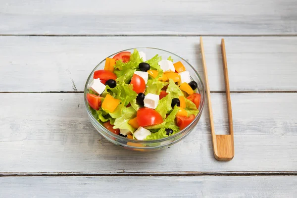 Griekse Salade Glazen Schaal Een Witte Houten Tafelondergrond — Stockfoto