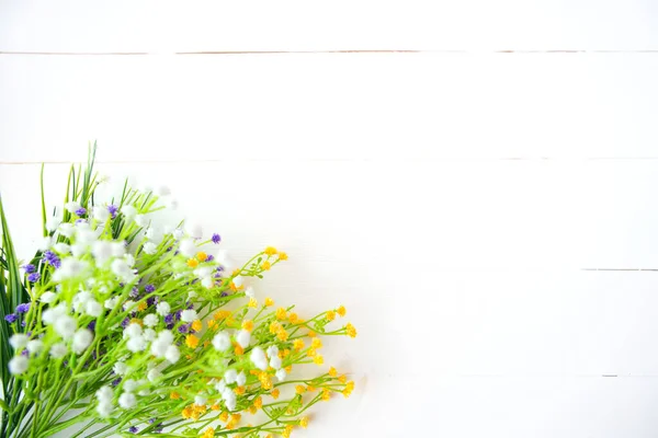 Plastikowe Kwiaty Białym Drewnianym Tle Stołu — Zdjęcie stockowe