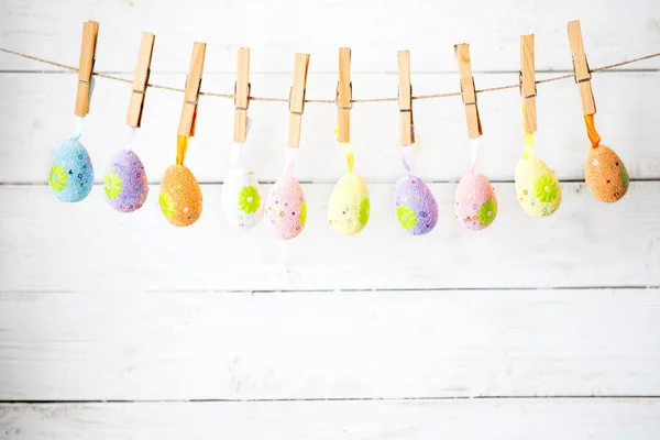 Coloridos Huevos Pascua Colgando Una Cuerda Sobre Fondo Blanco Rústico — Foto de Stock