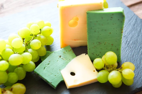 Diverse Kaassoorten Met Groene Druiven Zwart Leisteen Kaasplankje Tafel — Stockfoto