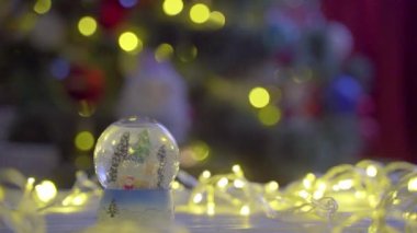 Noel ağacının arka planında Noel kar küresi