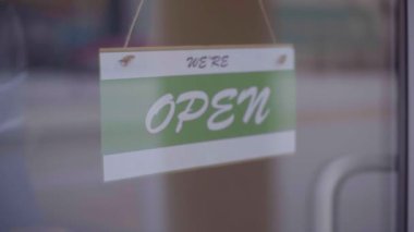 Covid yüzünden iş için kapatıldı. Küçük bir dükkan vitrine kapalı levha asıyor. Yavaş çekim